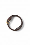 Brown leather belt with a gold buckle on a gray background